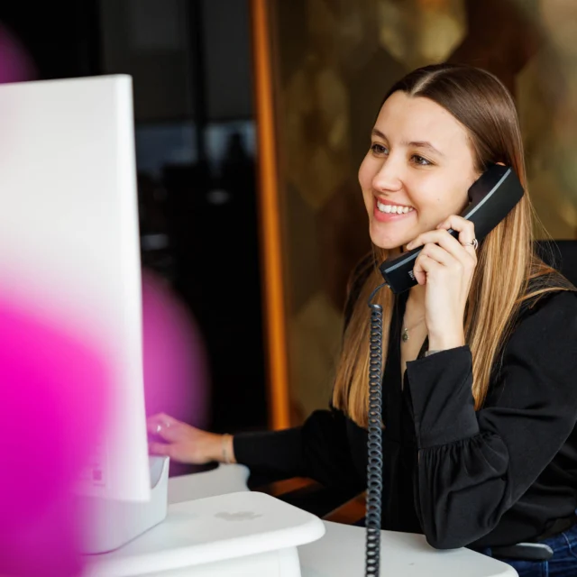 A woman taking a phone call at an office.